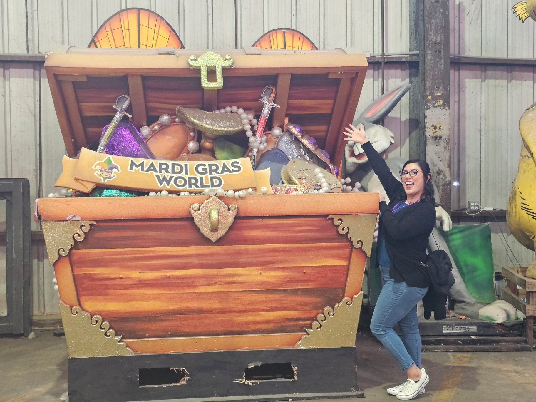 Woman posing beside a Mardi Gras treasure chest float