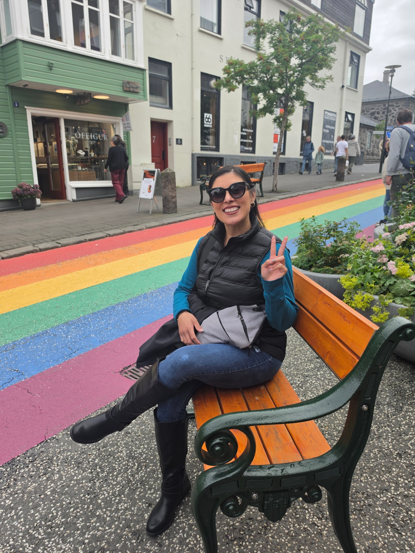 Woman on a bench beside the rainbow street in Reykjavík