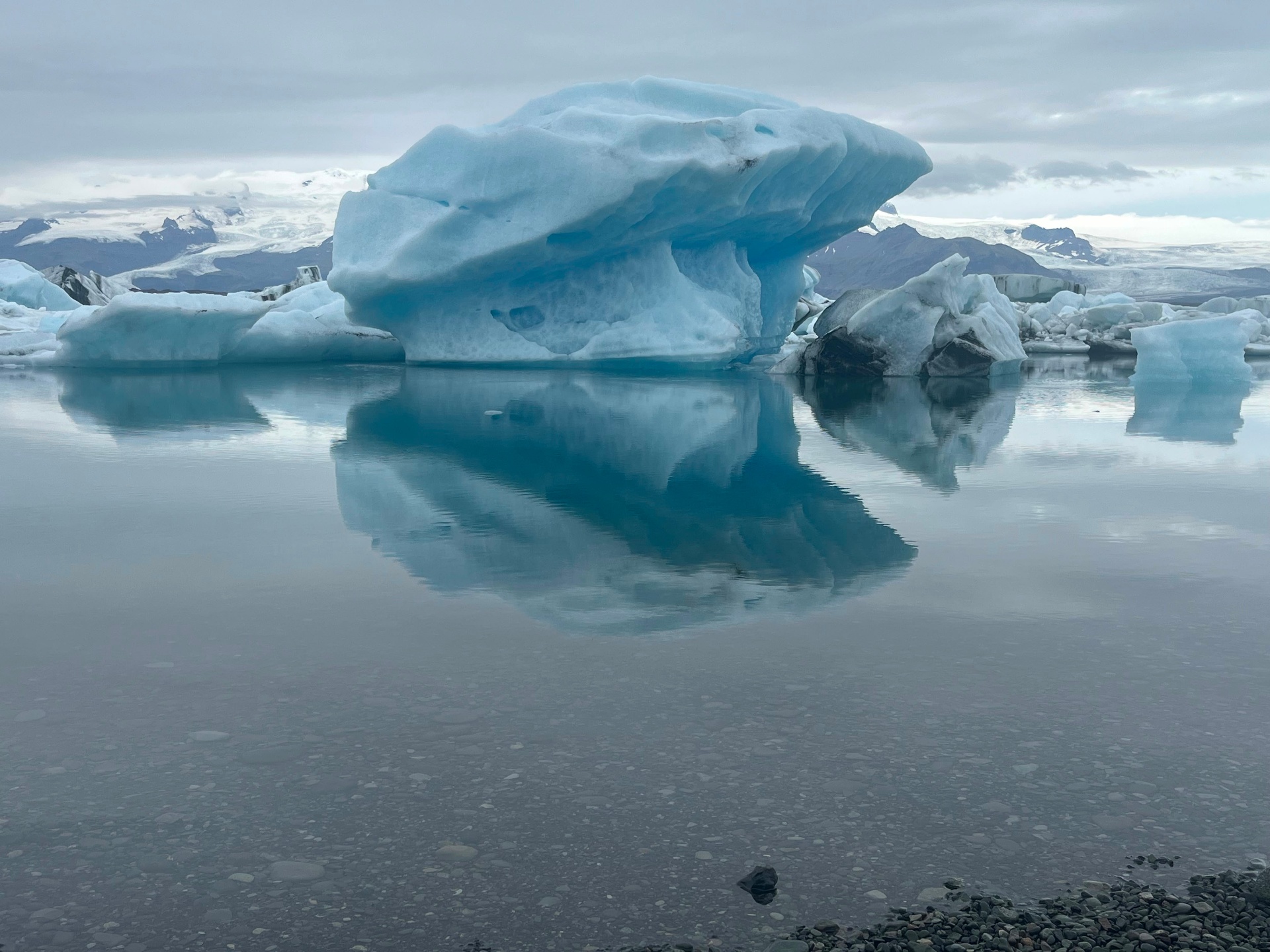 Blue iceberg mirrored in the still water of Jökulsárlón glacier lagoon