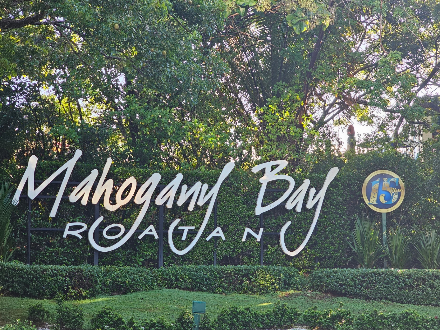 Mahogany Bay Roatan sign surrounded by greenery